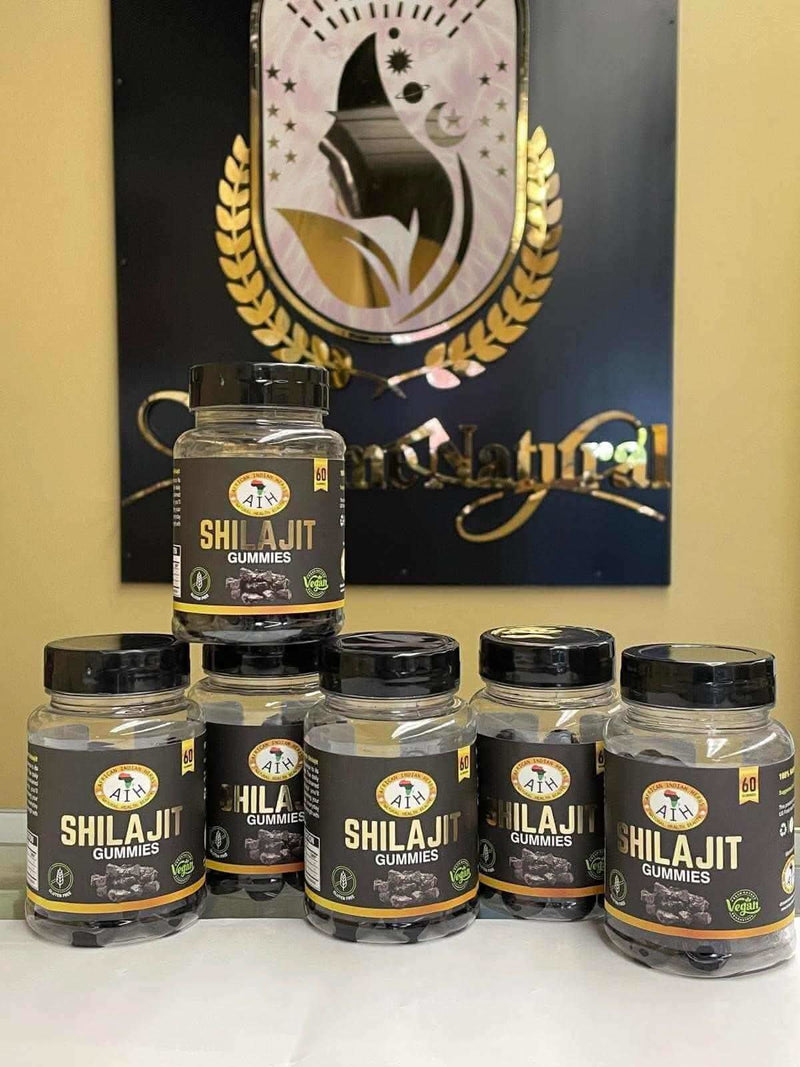 RoyalLuxsLLC Shilajit gummies in black labeled bottles arranged in front of branded sign