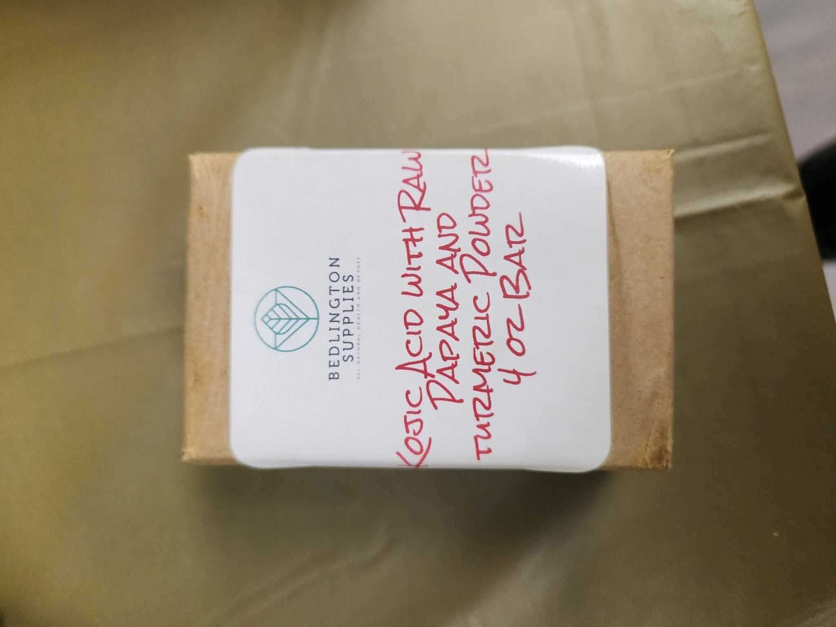 Kojic acid turmeric soap bar wrapped in brown paper with white label from RoyalLuxsLLC for body care