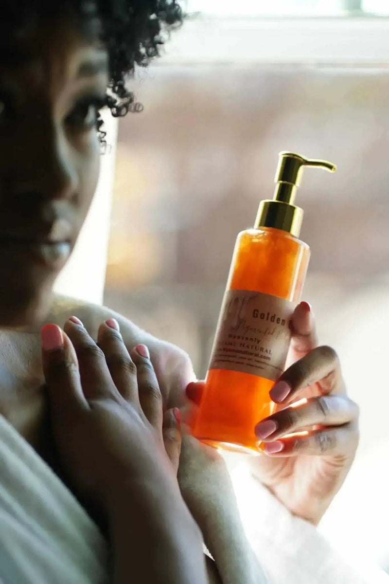 Woman holding RoyalLuxsLLC copper body oil in amber pump bottle applying to skin