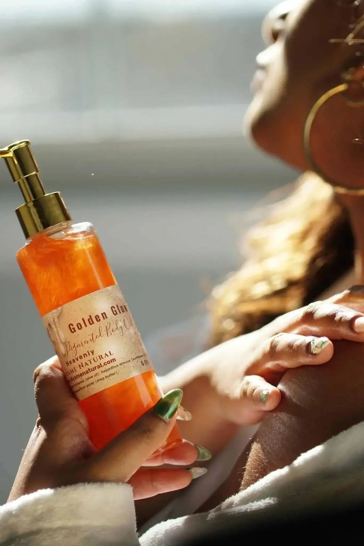 RoyalLuxsLLC copper body oil in clear bottle with gold pump being applied on shoulder