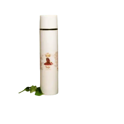 RoyalLuxsLLC white bottle of kojic body cream with natural green leaves on black background