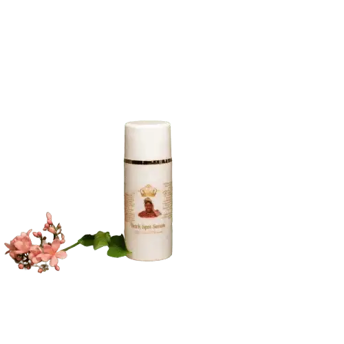 RoyalLuxsLLC white bottle of kojic dark spot serum next to a pink flower on black background