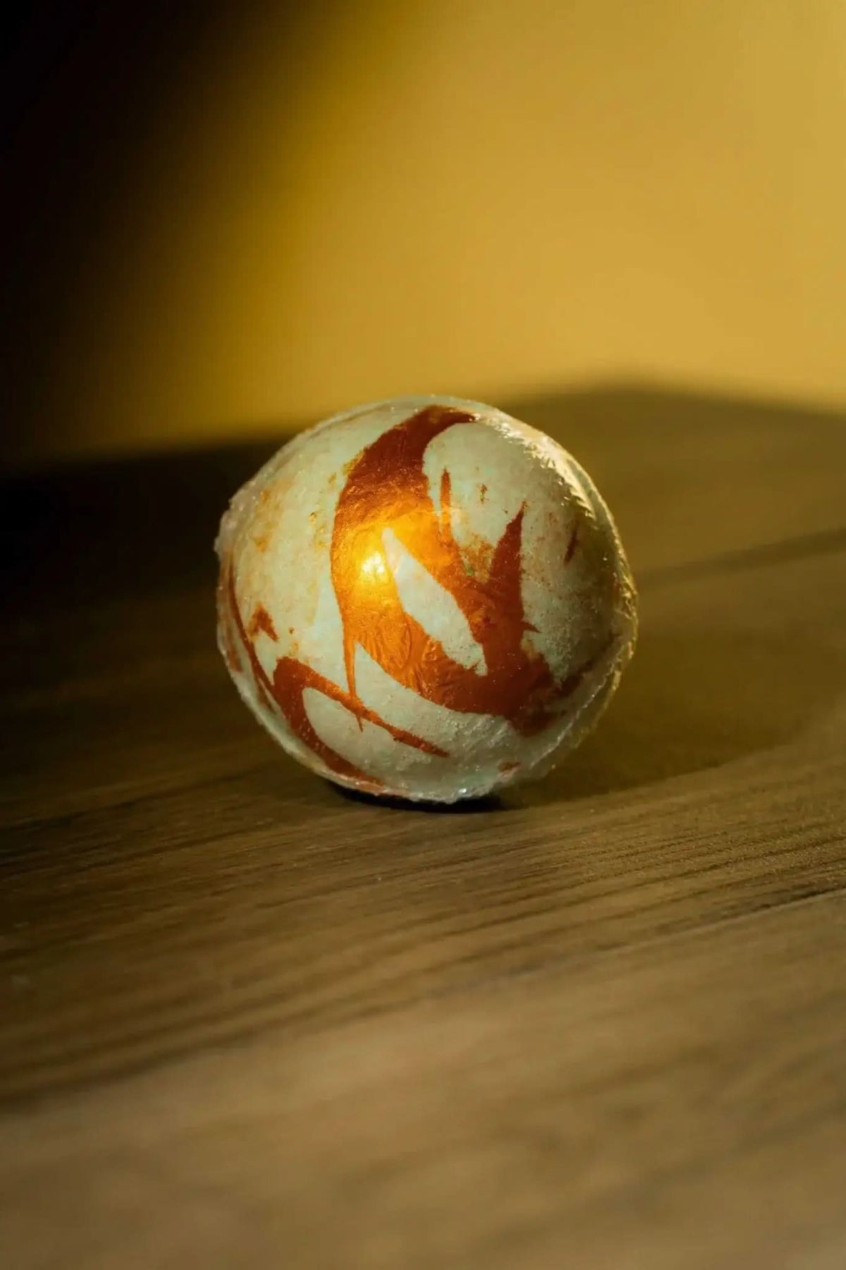 RoyalLuxsLLC luxurious herbal bath bomb with artistic brown swirls on a wooden surface