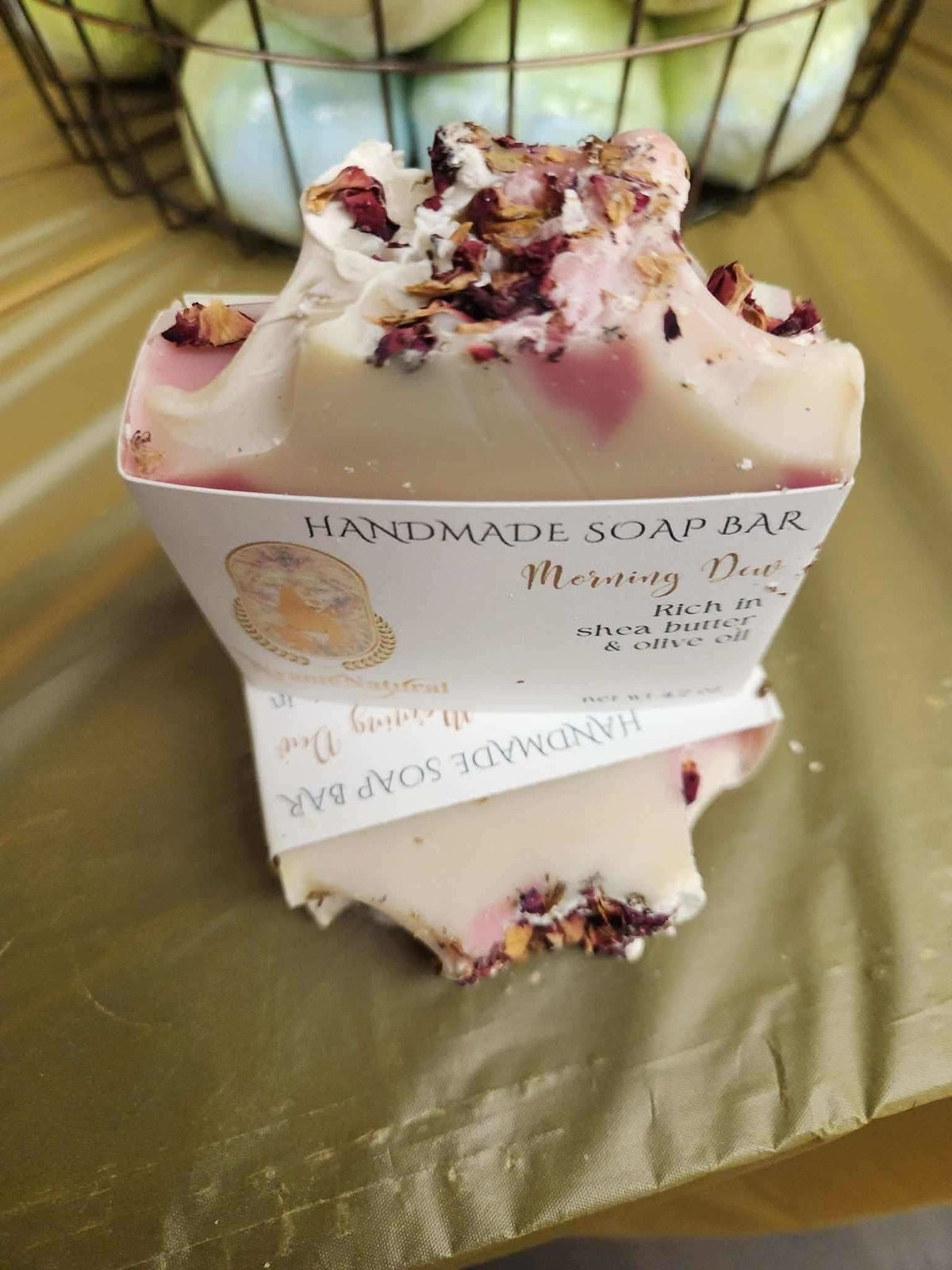 RoyalLuxsLLC natural handmade soap bar with dried flowers and creamy texture wrapped in branded paper