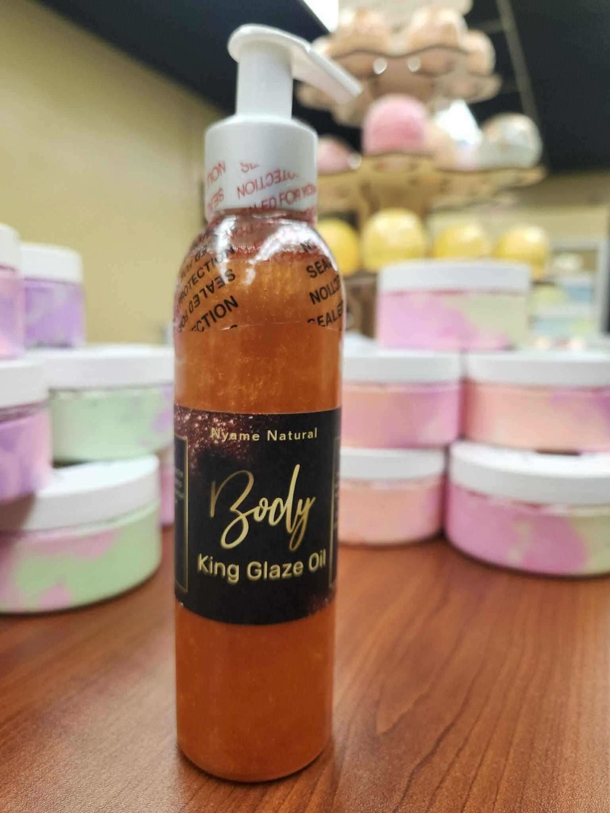RoyalLuxsLLC natural body oil for men in a pump bottle labeled King Glaze Oil on wooden surface