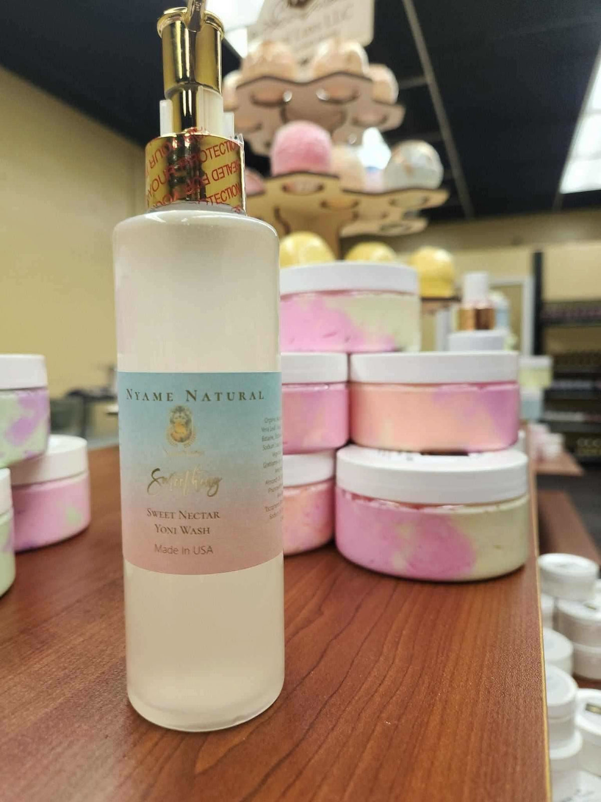 RoyalLuxsLLC herbal feminine wash in a clear pump bottle with pastel label on wooden surface