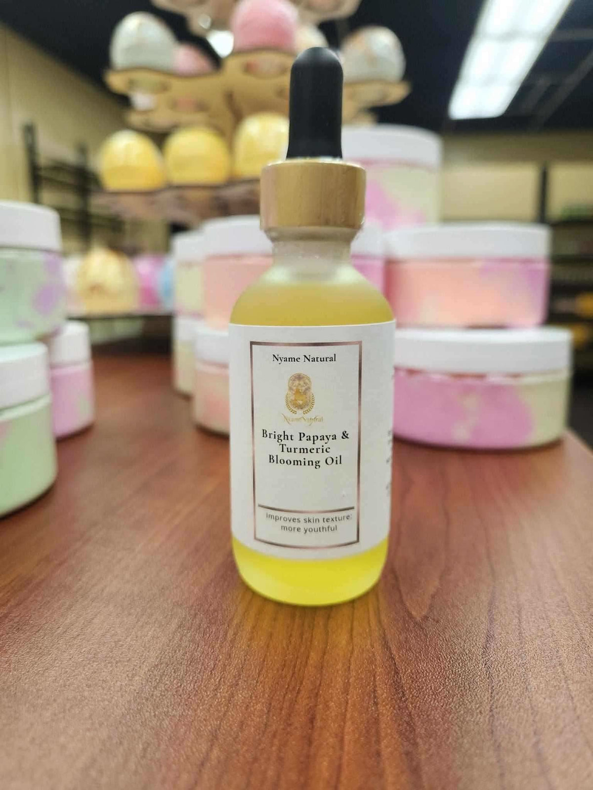 RoyalLuxsLLC papaya turmeric face oil in a dropper bottle with wooden cap on wooden surface