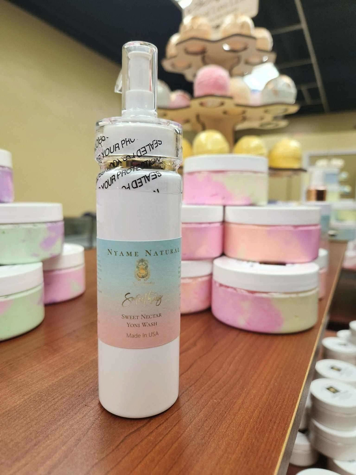 Natural yoni wash for women in a white pump bottle by RoyalLuxsLLC displayed on a wooden surface