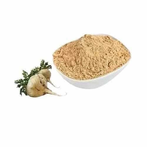 Bowl of organic maca root powder next to fresh maca root with green leaves