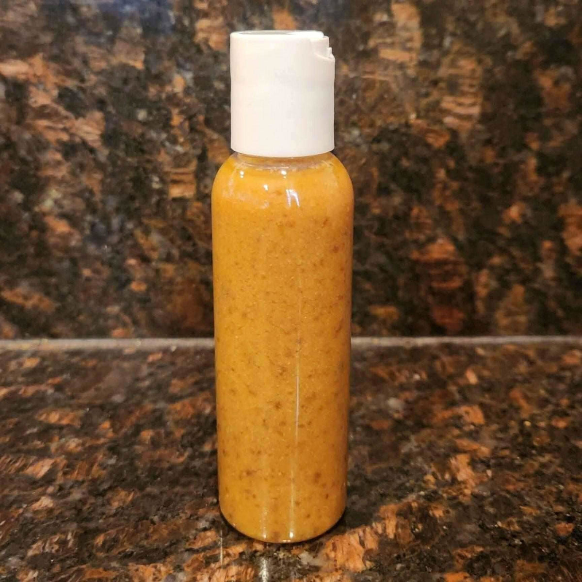 RoyalLuxsLLC natural stretch mark oil in a clear bottle with white cap on brown marble surface