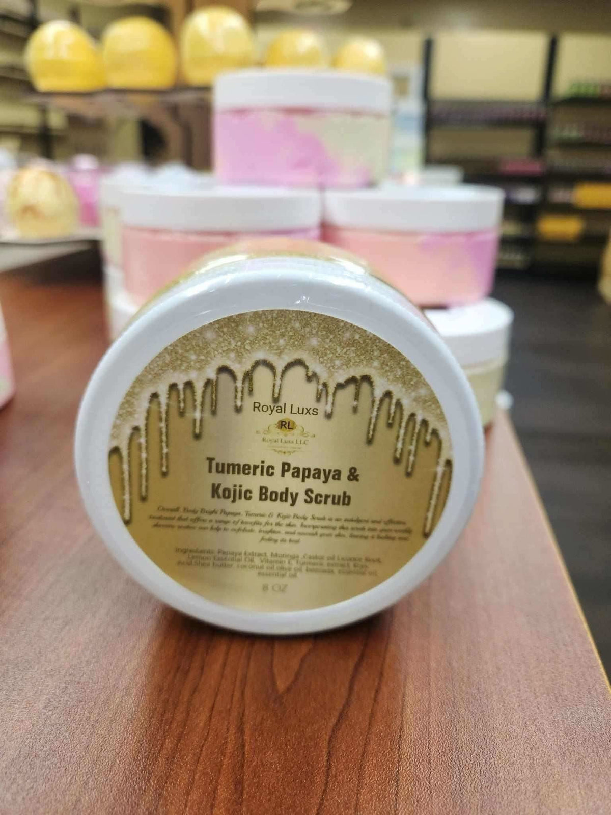 RoyalLuxsLLC turmeric papaya body scrub container with gold and white label on wooden surface