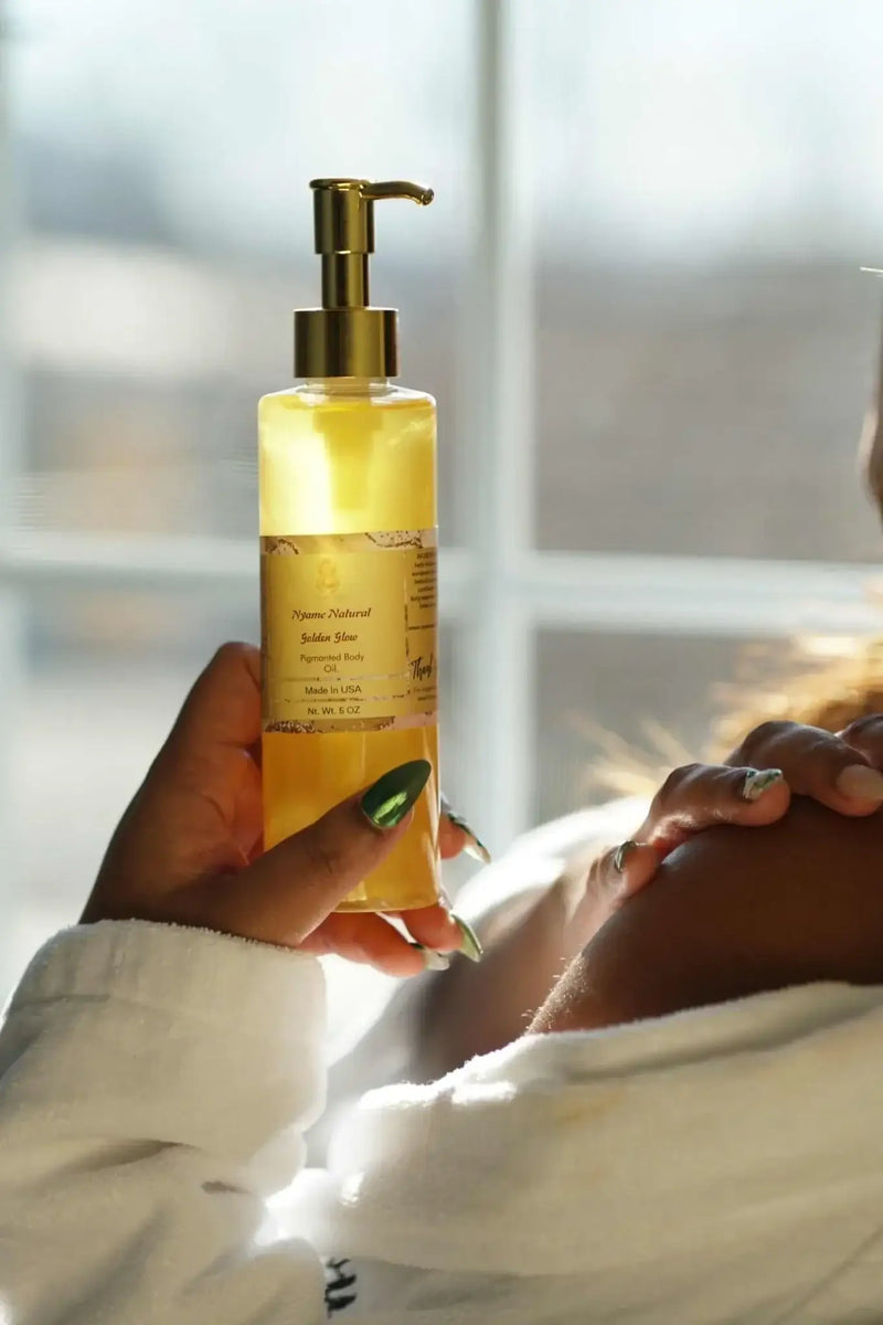 24k Gold Pigmented body oil in a pump bottle, enhancing radiance and providing deep moisturization for beautiful skin.