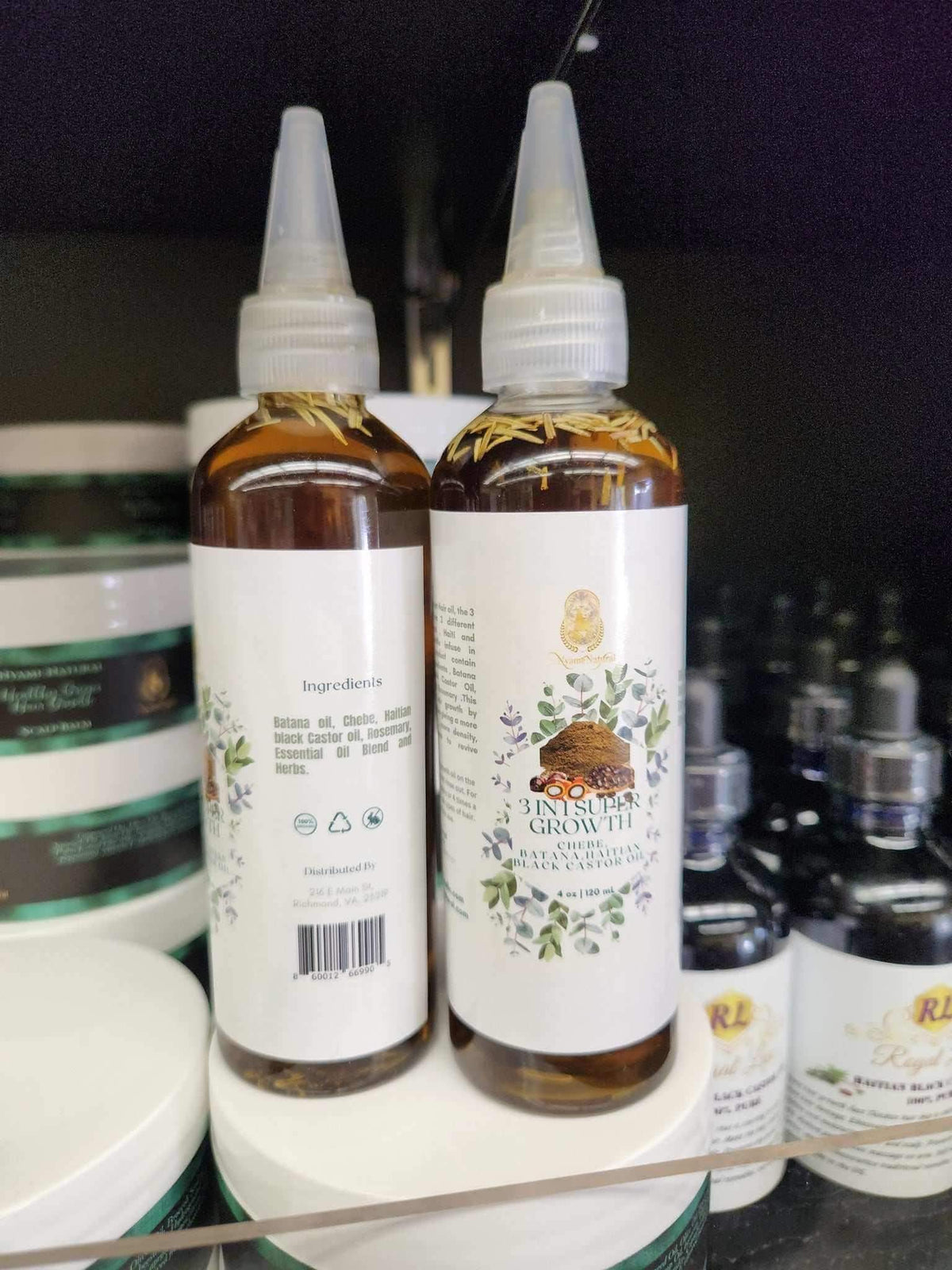 3 in 1 Supergrowth Batana Chebe Haitian Black Castor Oil bottles on a shelf, showcasing natural hair care benefits.