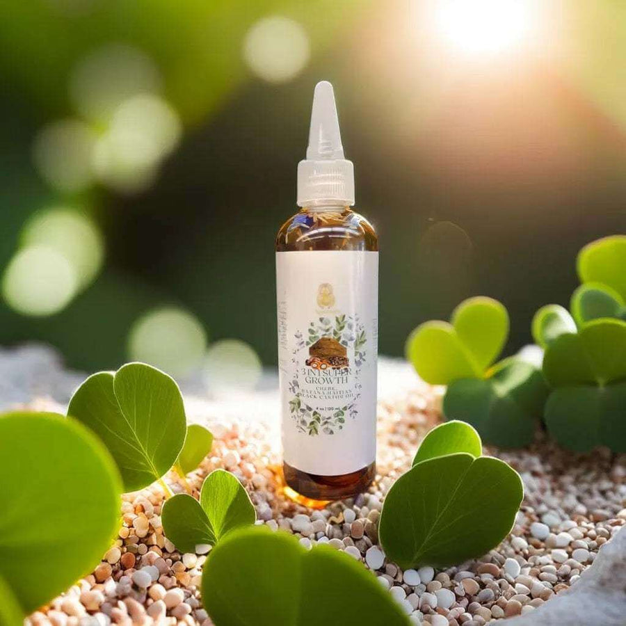 3 in 1 Supergrowth Batana Chebe Haitian Black Castor Oil bottle surrounded by green leaves and pebbles, perfect for hair growth.