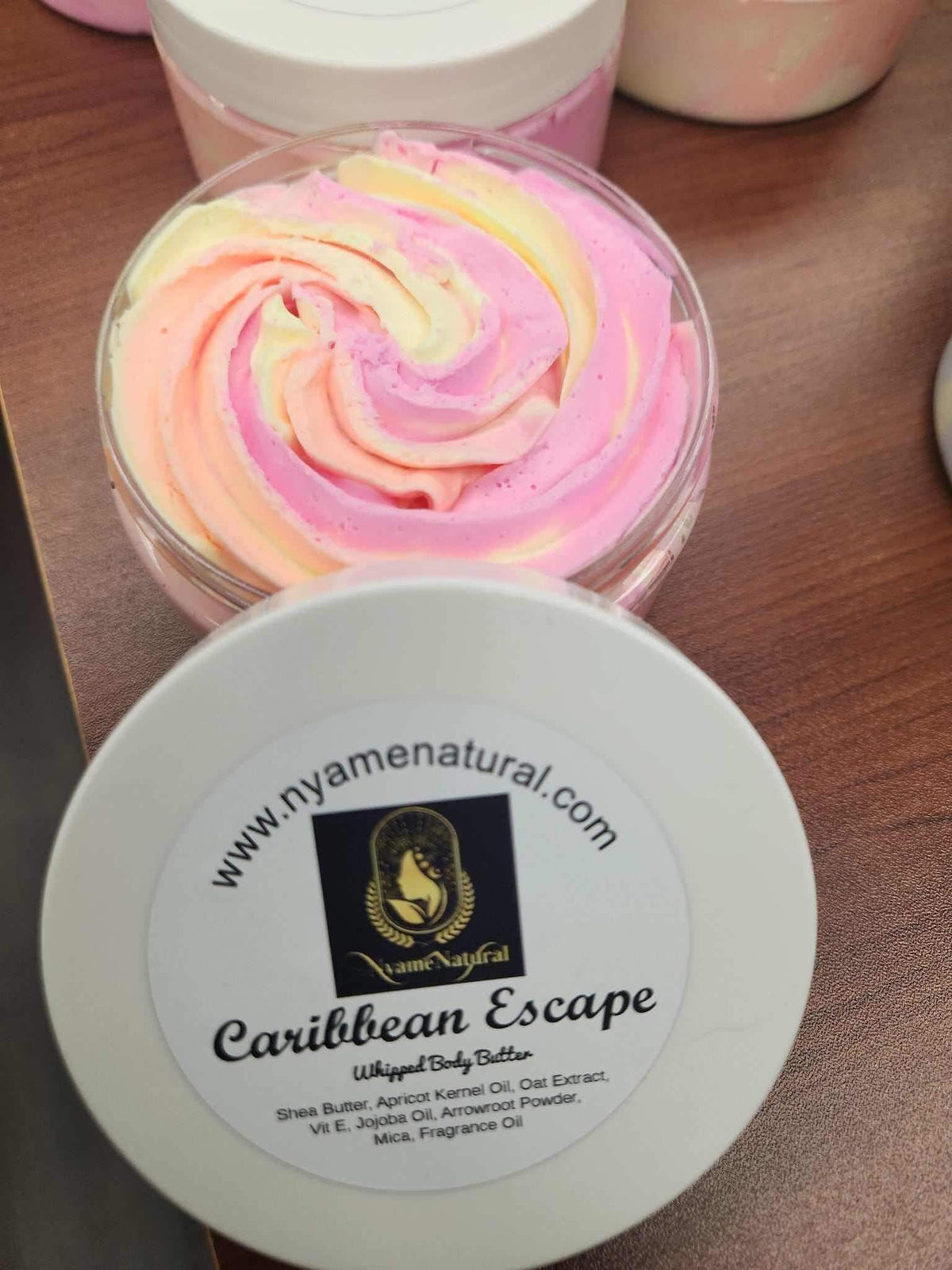 Caribbean Escape Body Butter in a jar, showcasing its creamy texture and delightful colors for luxurious skin nourishment.