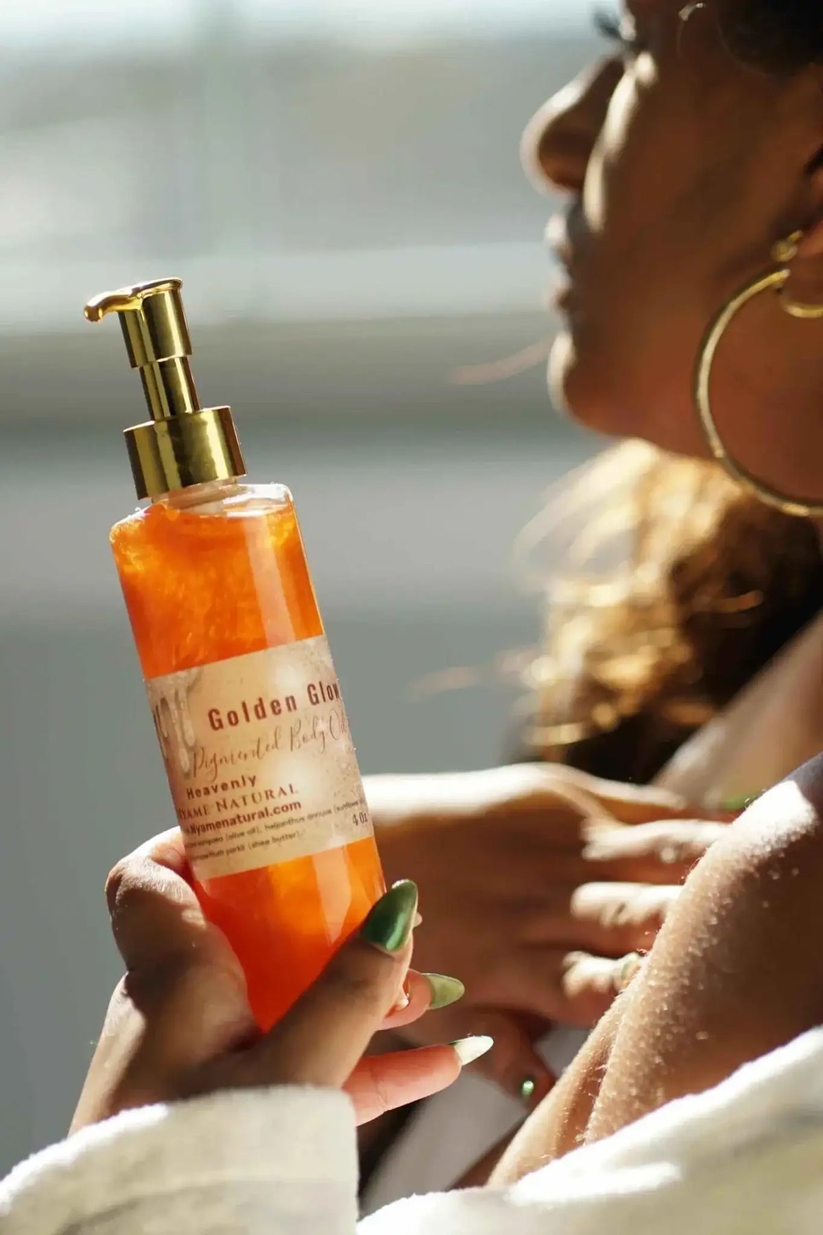 Copper Pigmented Body oil in hand, showcasing its luxurious golden glow, perfect for enhancing natural beauty.