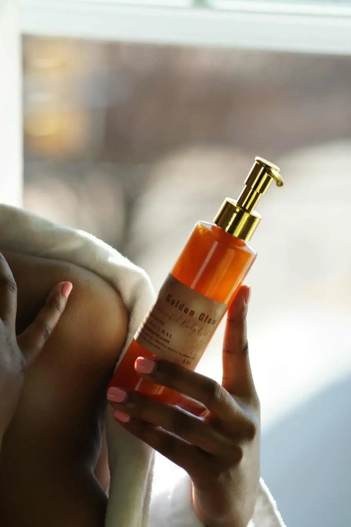 Copper Pigmented Body Oil in a hand, showcasing its luxurious texture and glow, perfect for detox and cleanse routines.