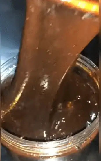 Lusciousness Drip Honey (Kayanmata)Goron Tula being poured from a jar, showing its rich texture and organic quality.