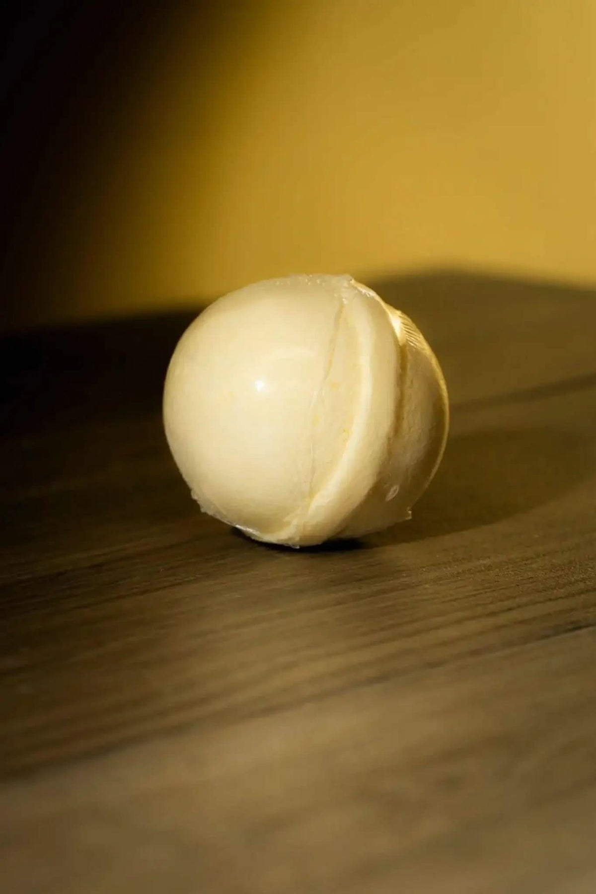 RoyalLuxsLLC luxurious herbal bath bomb in smooth creamy white on wooden surface