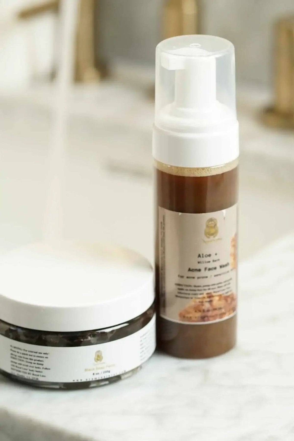 RoyalLuxsLLC natural acne face wash for sensitive skin in a pump bottle displayed with a jar on marble surface