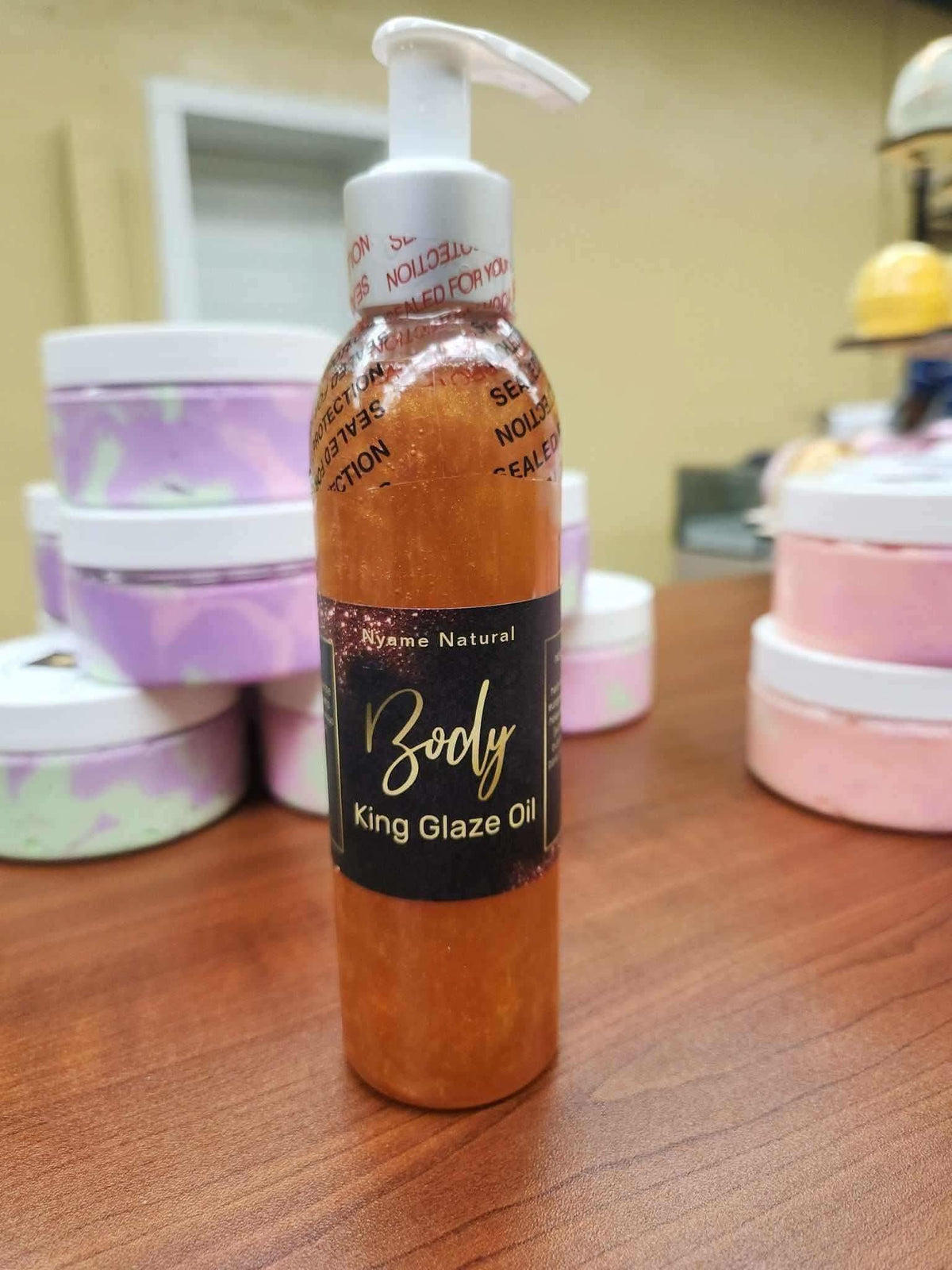 Natural body oil for men in a clear pump bottle labeled King Glaze Oil with shimmering golden color