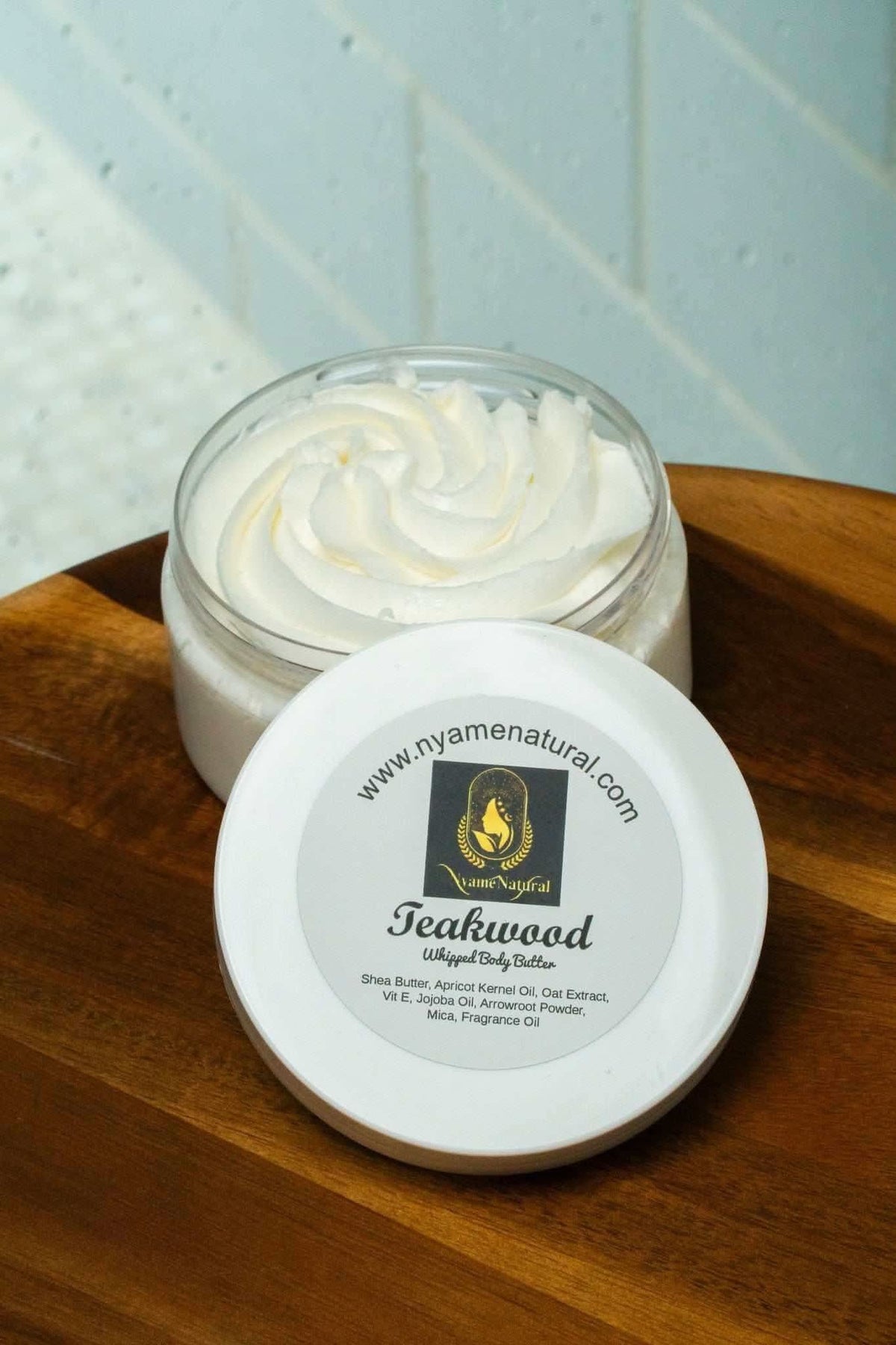 RoyalLuxsLLC teakwood body butter in open jar showing creamy texture on wooden surface