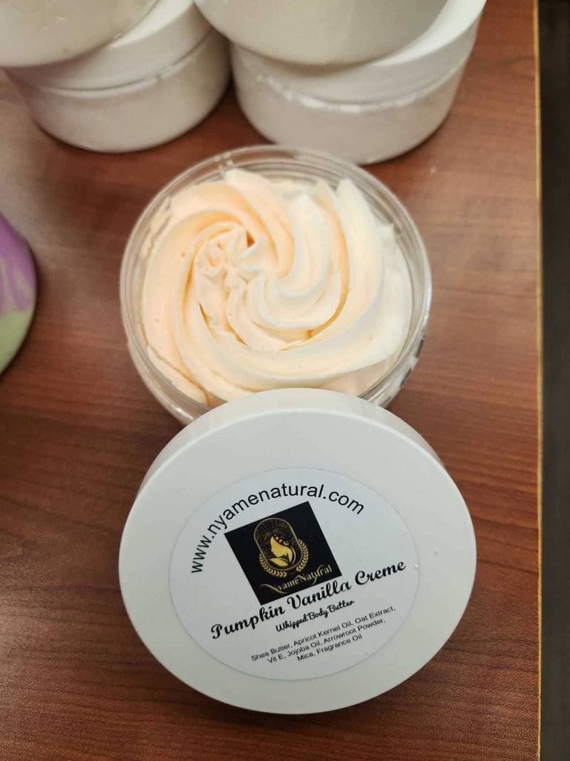 RoyalLuxsLLC pumpkin vanilla body butter in a clear jar with creamy swirl texture on wooden surface