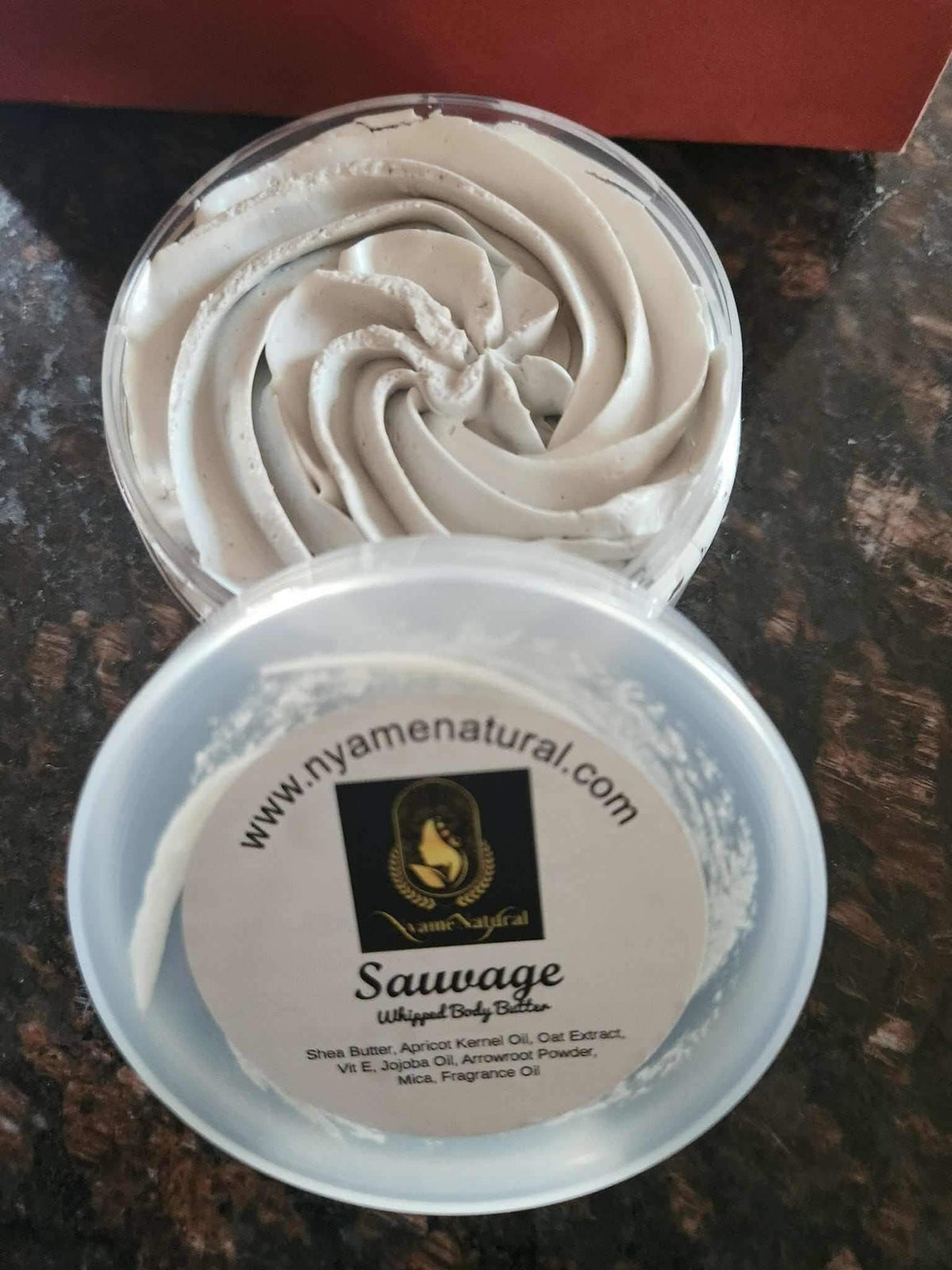 Sauvage Luxury Body Butter in a clear jar showcasing creamy whipped texture for deep nourishment and hydration.