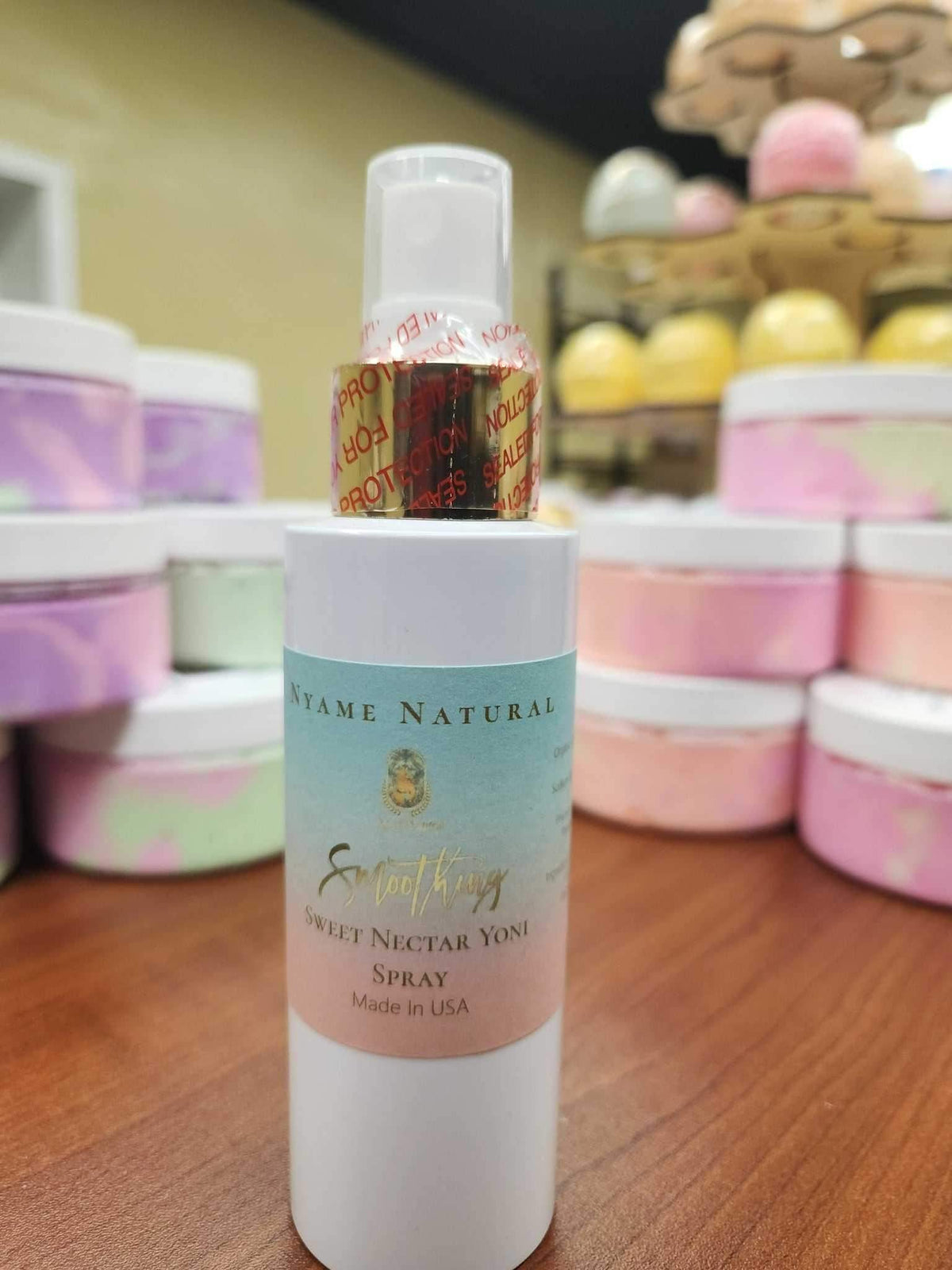 Sweet Yonie Spray bottle displayed among colorful bath products, promoting freshness and confidence for personal hygiene.