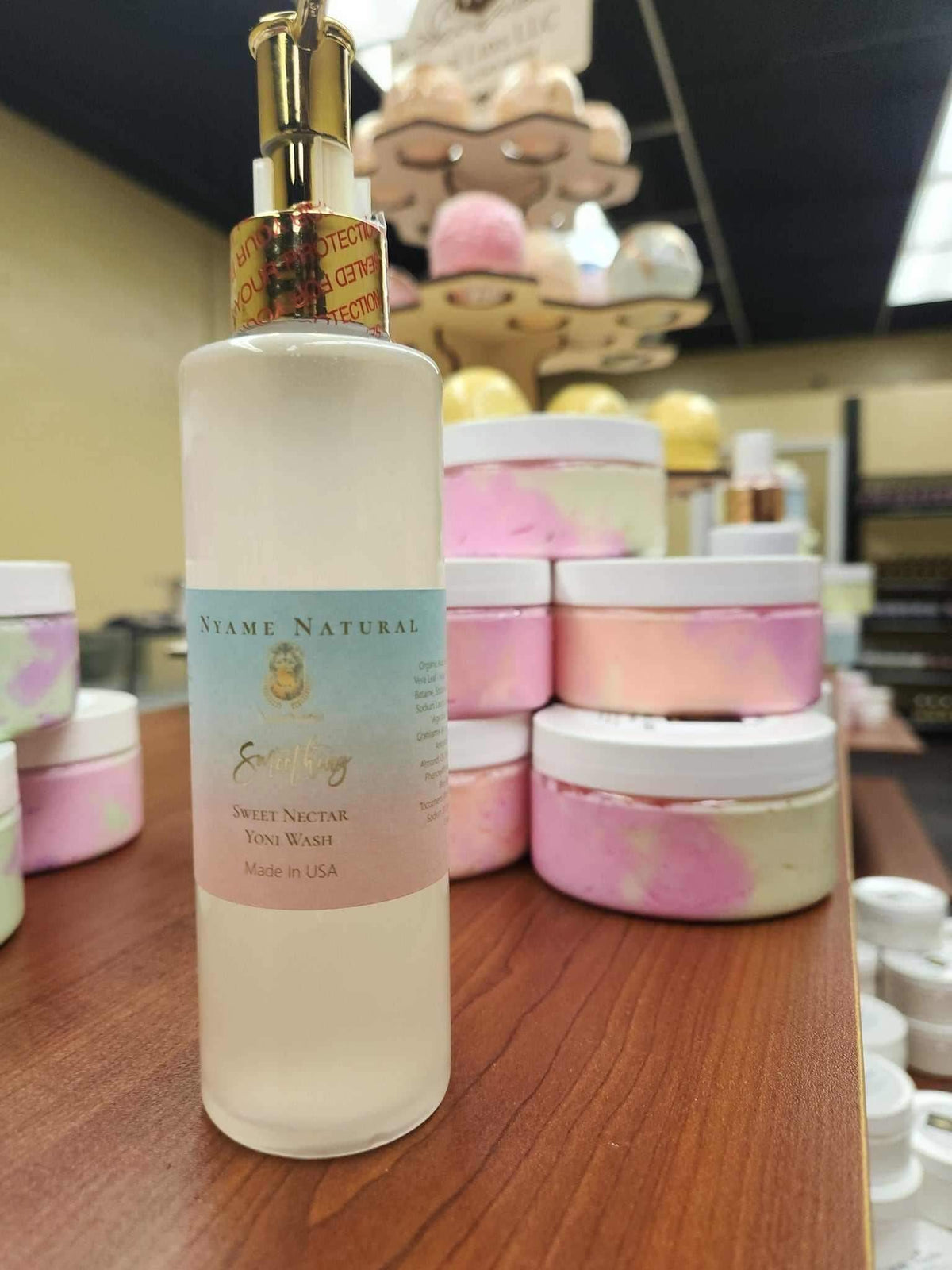 Sweet Yonie Wash bottle with pink and white cream jars, featuring organic ingredients for feminine freshness and comfort.
