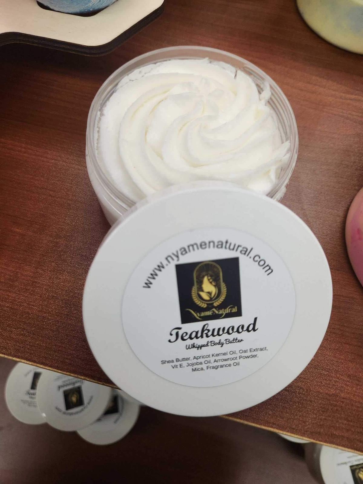 Teakwood Body butter in a jar on a wooden surface, promoting skin nourishment and hydration.