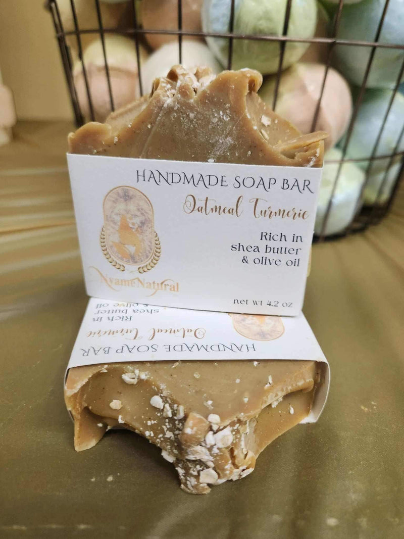Turmeric & Oat Meal soap bar resting on a table, showcasing its rich color and natural ingredients for cleansing.